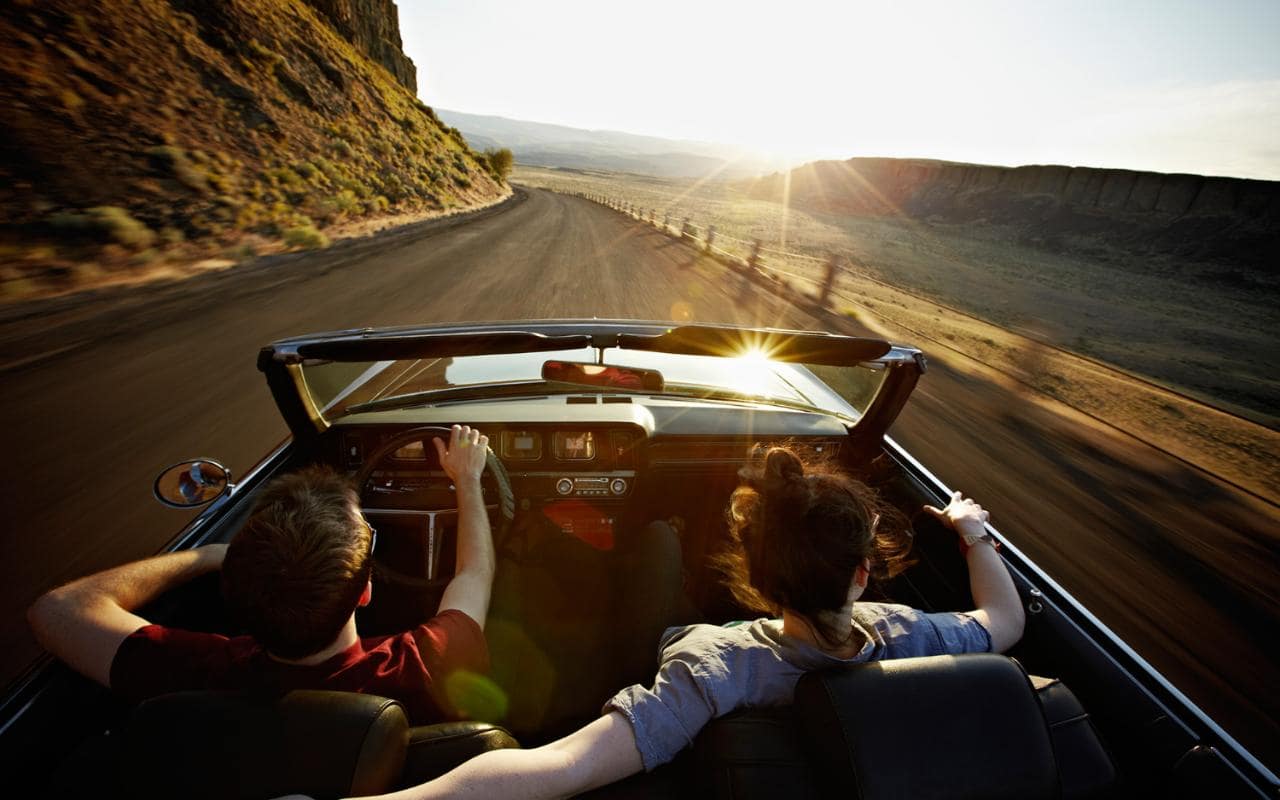 couple driving open top car